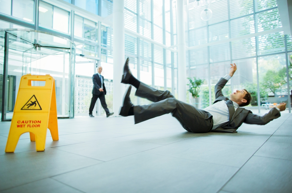 A man in a suit slips on a wet floor