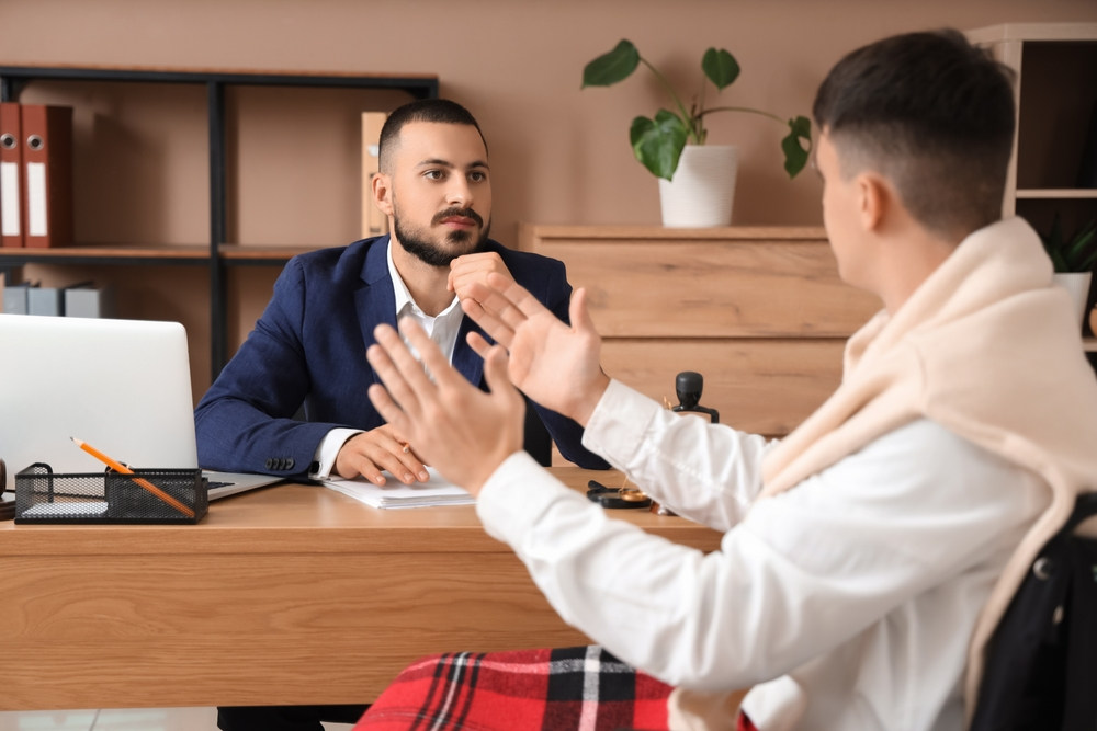 Two men are having a focused conversation in an office